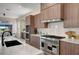 Chef's kitchen with professional-grade appliances, wood cabinetry, and a marble backsplash at 4574 Fiore Bella Blvd, Las Vegas, NV 89135