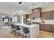 A stylish kitchen with wood cabinets, marble countertops, and a large island with seating at 4574 Fiore Bella Blvd, Las Vegas, NV 89135