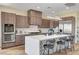 Modern kitchen featuring stainless steel appliances, wood cabinetry, and a marble island with seating at 4574 Fiore Bella Blvd, Las Vegas, NV 89135