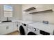 Laundry room featuring white cabinets, floating shelves, and LG washer and dryer at 4574 Fiore Bella Blvd, Las Vegas, NV 89135