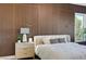 Close-up showcasing a primary bedroom's decorative wood accent wall and bedside details at 4574 Fiore Bella Blvd, Las Vegas, NV 89135