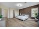 Well-lit primary bedroom featuring modern wood accents, a cozy seating area, and luxurious finishes at 4574 Fiore Bella Blvd, Las Vegas, NV 89135