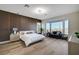 Serene primary bedroom boasting a bay window, wood accent wall, and stylish furnishings at 4574 Fiore Bella Blvd, Las Vegas, NV 89135