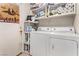 Bright laundry room with washer, dryer, and ample storage shelving for convenience at 4919 Rancho Domingo Ct, North Las Vegas, NV 89031
