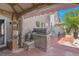 Outdoor living space featuring a built-in grill, covered patio, hot tub, and comfortable seating at 4992 W Moberly Ave, Las Vegas, NV 89139