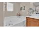 Bathroom showcasing a soaking tub with chrome fixtures and a granite countertop vanity at 4992 W Moberly Ave, Las Vegas, NV 89139
