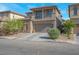 Two-story home featuring a balcony, neutral stucco, stone accents, finished two-car garage and manicured landscaping at 4992 W Moberly Ave, Las Vegas, NV 89139