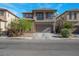 Two-story home featuring a balcony, neutral stucco, stone accents, finished two-car garage and manicured landscaping at 4992 W Moberly Ave, Las Vegas, NV 89139