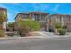 Two-story home featuring a balcony, neutral stucco, stone accents, finished two-car garage and manicured landscaping at 4992 W Moberly Ave, Las Vegas, NV 89139