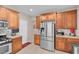 Well-lit kitchen featuring wooden cabinets, stainless steel appliances and tile flooring at 4992 W Moberly Ave, Las Vegas, NV 89139