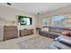 Inviting living room with tile flooring, a comfortable sectional sofa, and a large entertainment center at 4992 W Moberly Ave, Las Vegas, NV 89139