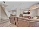 Bright living room with a staircase, dining room, and cozy seating area centered around a large flatscreen TV at 4992 W Moberly Ave, Las Vegas, NV 89139