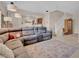 Open-concept living space with a large sectional sofa, staircase and dining area visible at 4992 W Moberly Ave, Las Vegas, NV 89139