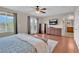 Main bedroom showcasing wood floors, a TV, balcony doors, and an ensuite bathroom at 4992 W Moberly Ave, Las Vegas, NV 89139