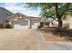 Charming single-story home featuring a three-car garage and beautifully landscaped front yard with mature shade tree at 51 La Fiesta St, Henderson, NV 89012