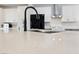 Close up of a light countertop with dark faucet, accented by black appliances in the kitchen at 51 La Fiesta St, Henderson, NV 89012