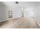 Spacious living room with light wood floors, ceiling fan, and access to a bathroom at 51 La Fiesta St, Henderson, NV 89012