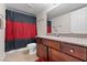 This bathroom features a dark wood vanity with granite counters and a red and black shower curtain at 5185 Indian River Dr # 229, Las Vegas, NV 89103