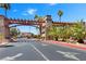 Community entrance features a decorative wood arbor with stone pillars and manicured landscaping including palm trees at 5185 Indian River Dr # 229, Las Vegas, NV 89103