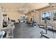 A clean, well-equipped community fitness center with machines and mirrors, next to a pool with palm trees outside at 5185 Indian River Dr # 229, Las Vegas, NV 89103