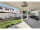 Spacious backyard featuring a covered patio with outdoor seating, grill, and artificial lawn with playful swing set at 5220 Remini Ct, Las Vegas, NV 89130