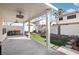 Covered backyard patio featuring sleek ceiling fans and an artificial lawn with playful swing set at 5220 Remini Ct, Las Vegas, NV 89130
