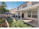 Spacious backyard featuring a covered patio with outdoor seating, grill, and artificial lawn with playful swing set at 5220 Remini Ct, Las Vegas, NV 89130