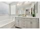 A bathroom with a double vanity, large mirror, soaking tub and recessed lighting at 5220 Remini Ct, Las Vegas, NV 89130
