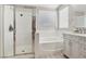 An all white bathroom with a shower, soaking tub, and double vanity at 5220 Remini Ct, Las Vegas, NV 89130