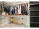 A walk-in closet with a variety of clothes, shoes, and wood shelving at 5220 Remini Ct, Las Vegas, NV 89130