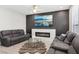 Modern living room featuring a stylish fireplace, large screen television, and comfortable couches at 5220 Remini Ct, Las Vegas, NV 89130
