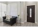 Elegant entryway featuring a sleek black couch, decorative details and a modern front door at 5220 Remini Ct, Las Vegas, NV 89130