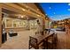 Expansive backyard patio featuring outdoor dining, string lights, and lush greenery, perfect for entertaining at 5523 Kyle Peak Ct, Las Vegas, NV 89135
