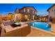 Inviting backyard boasts a sparkling pool, cozy seating around a fire pit, and charming string lights for evening ambiance at 5523 Kyle Peak Ct, Las Vegas, NV 89135