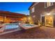 Beautiful backyard showcasing a shimmering pool with an attached spa, complemented by a spacious brick patio and lounge area at 5523 Kyle Peak Ct, Las Vegas, NV 89135