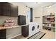 Well-organized laundry room featuring modern washer and dryer, folding area, mini-fridge, and built-in storage shelves for convenience at 5523 Kyle Peak Ct, Las Vegas, NV 89135