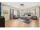 Spacious main bedroom featuring hardwood floors, a ceiling fan, and a comfortable seating area with decorative pillows at 5523 Kyle Peak Ct, Las Vegas, NV 89135
