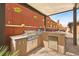 Outdoor kitchen featuring a built-in grill and granite countertop, perfect for alfresco dining and entertaining at 5523 Kyle Peak Ct, Las Vegas, NV 89135