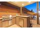 Outdoor kitchen with stainless grill, granite counter, and seating area at 5523 Kyle Peak Ct, Las Vegas, NV 89135