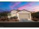 Charming single-story home boasting manicured landscaping, a two-car garage, and a warm, inviting facade at dusk at 5618 E San Marco Dr, Pahrump, NV 89061