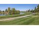 Picturesque view of a beautifully maintained golf course with mature trees and a scenic pond at 5618 E San Marco Dr, Pahrump, NV 89061