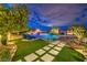 Inviting backyard with lush landscaping, sparkling pool, and comfortable seating area, perfect for entertaining at 62 Grand Masters Dr, Las Vegas, NV 89141