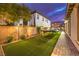 Spacious backyard with artificial turf, trampoline, and lush landscaping, ideal for recreation at 62 Grand Masters Dr, Las Vegas, NV 89141
