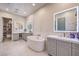 Spa-like bathroom featuring double vanity, soaking tub, and modern lighting at 62 Grand Masters Dr, Las Vegas, NV 89141