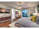 Comfortable bedroom with a modern dresser, chandelier, and sliding glass doors at 62 Grand Masters Dr, Las Vegas, NV 89141