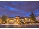 Charming single story home with stone accents, a three car garage and manicured landscaping at twilight at 62 Grand Masters Dr, Las Vegas, NV 89141