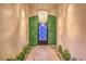 Unique front door with stone walk and green wall illuminated by decorative chandelier at 62 Grand Masters Dr, Las Vegas, NV 89141