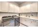 Well-equipped laundry room with modern washer and dryer units and a sink at 62 Grand Masters Dr, Las Vegas, NV 89141