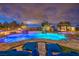 Stunning pool and hot tub area with lounge chairs and lush landscaping at twilight at 62 Grand Masters Dr, Las Vegas, NV 89141