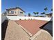 Spacious backyard featuring stone landscaping and a patio, with palm trees in the horizon at 66 John Stuart Mill St, Henderson, NV 89002